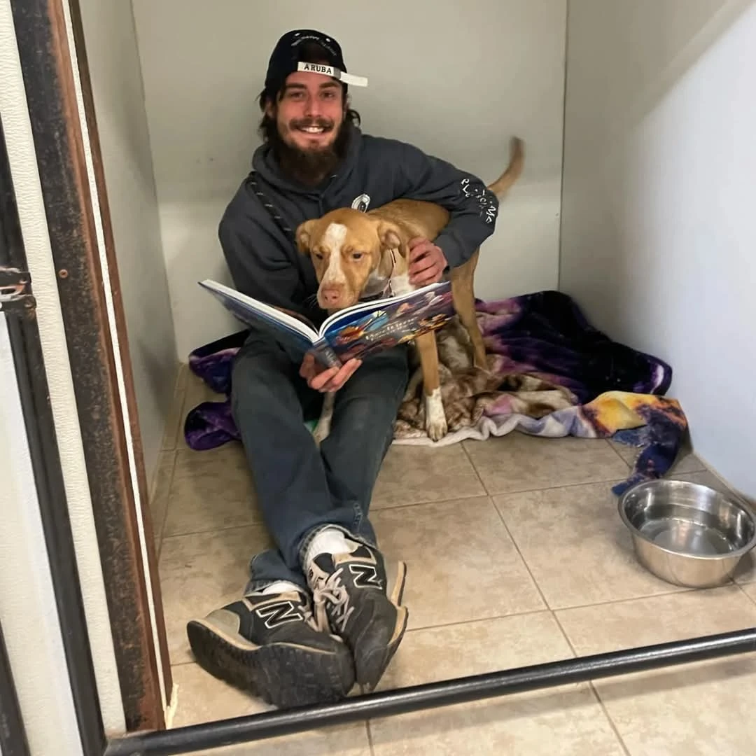 pet sitter reading a bed time story to a dog