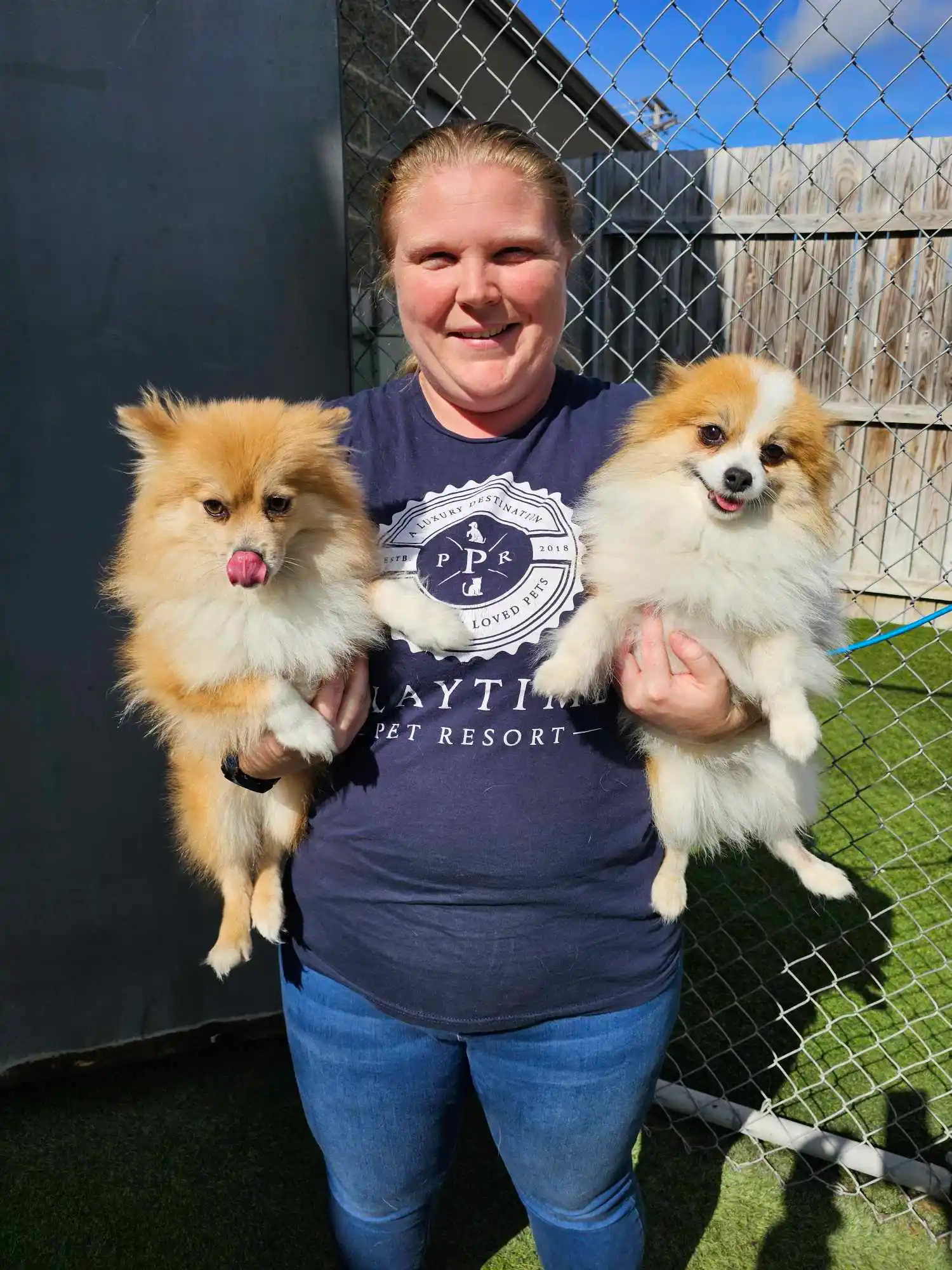 two dogs being picked up in each arm